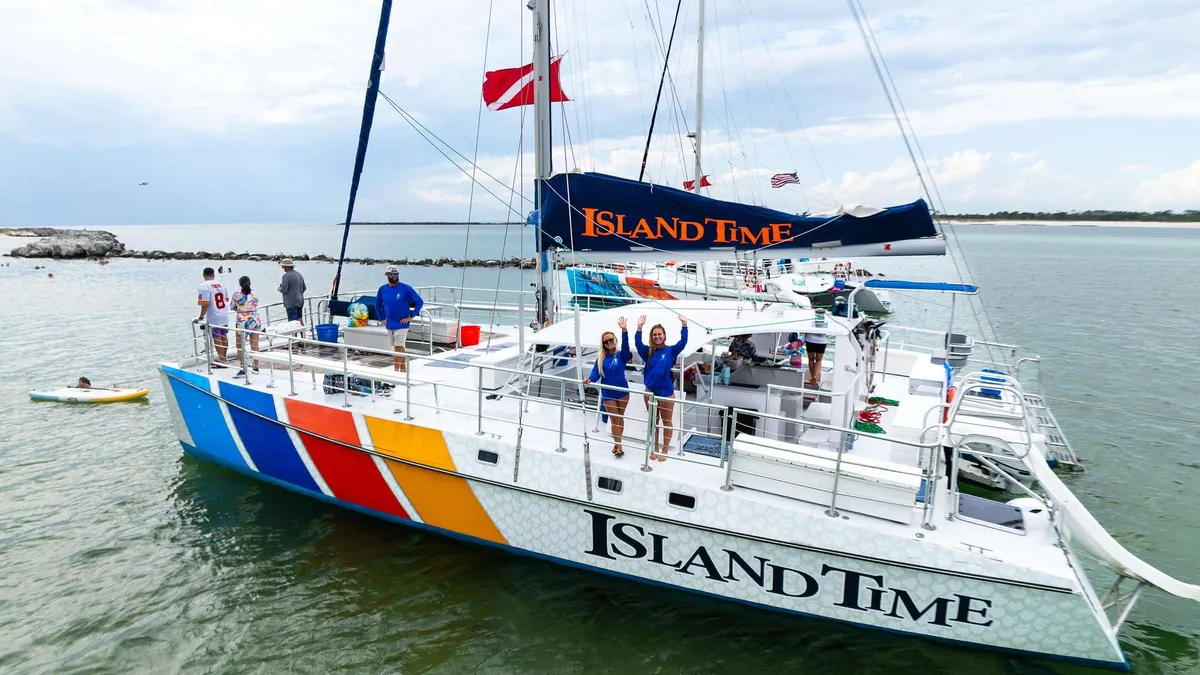 A catamaran anchored over clear shallow water on a Shell Island Florida snorkeling and dolphin cruise off Panama City Beach